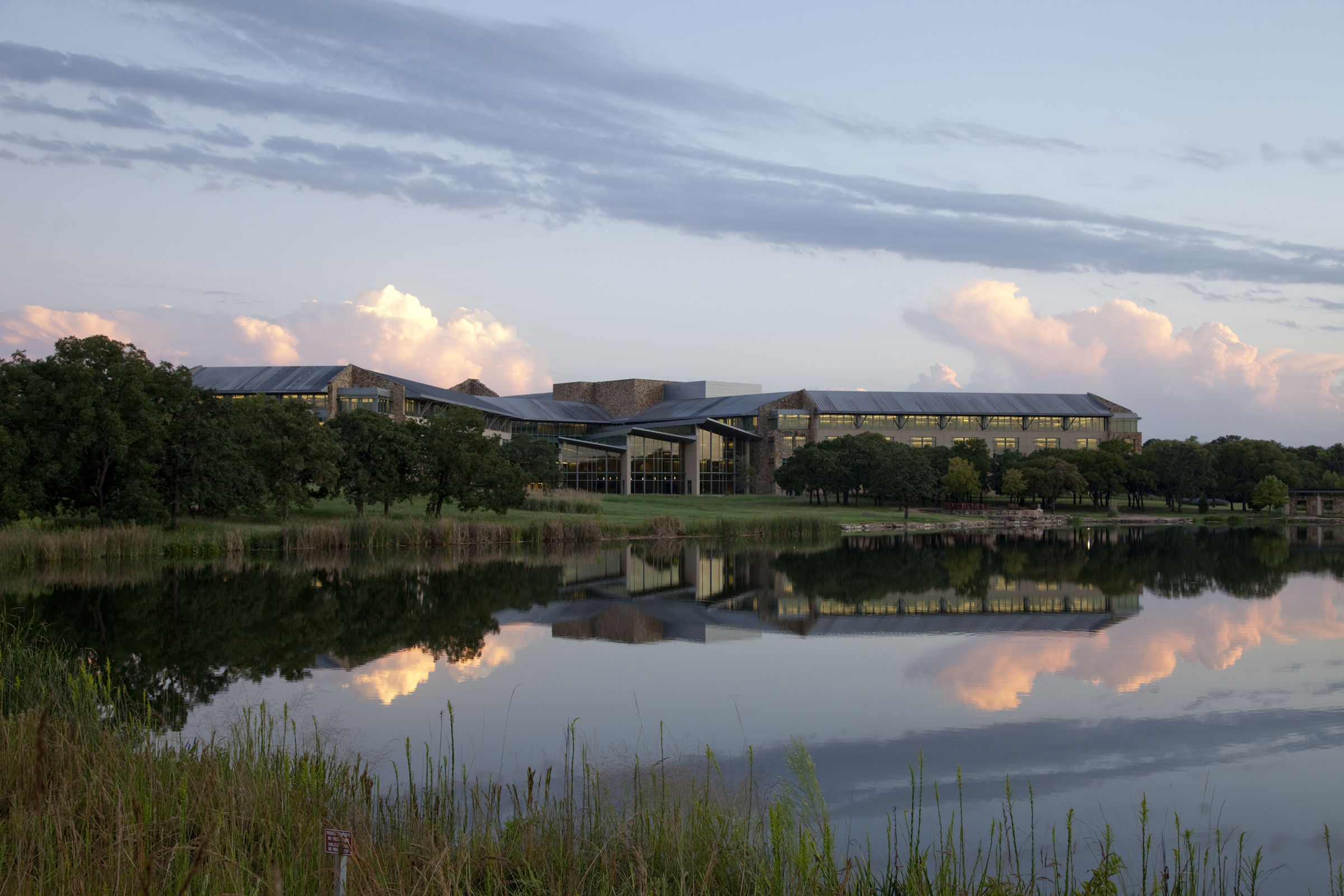 a building with trees and a body of water