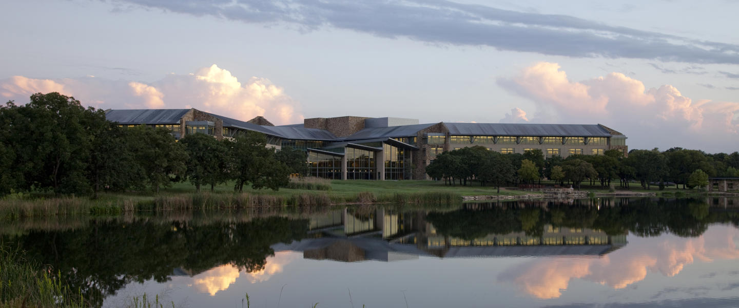 a building with trees and a body of water