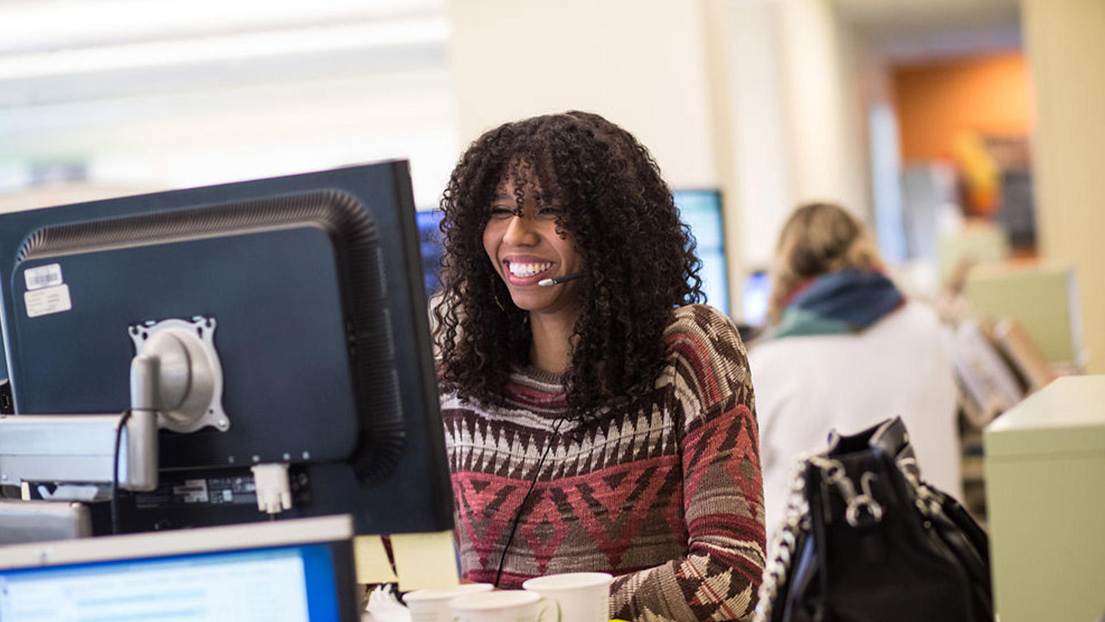 a person smiling at a computer